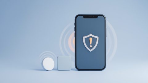 Conceptual illustration of two small round Bluetooth trackers beside a phone showing a warning shield, evoking unknown-tracker safety alerts